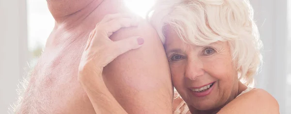 Senior vrouw knuffelen naakte mannen borst — Stockfoto