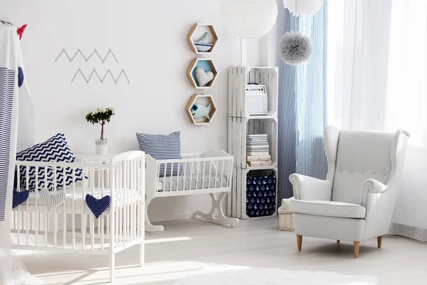 Детская комната с белым стулом и колыбелью — стоковое фото