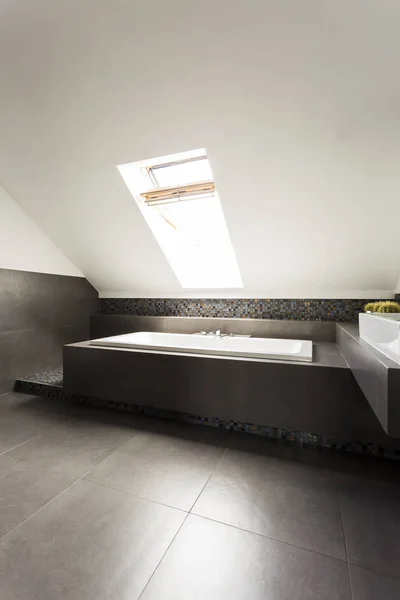 Ascetic attic bathroom with bathtub — Stock Photo, Image