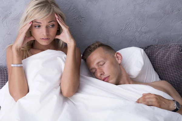 Испуганная женщина в постели с любовником — стоковое фото