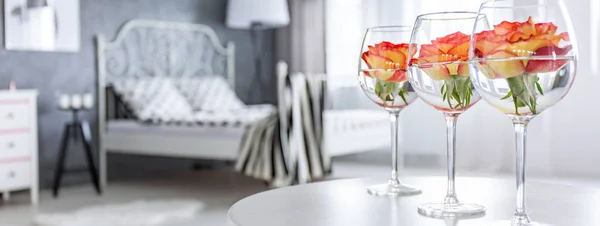 Gläser mit Rosen auf dem Tisch — Stockfoto