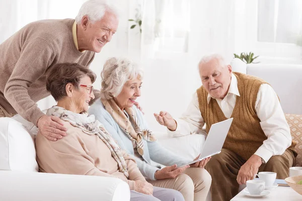 Grupo de idosos com computador portátil — Fotografia de Stock