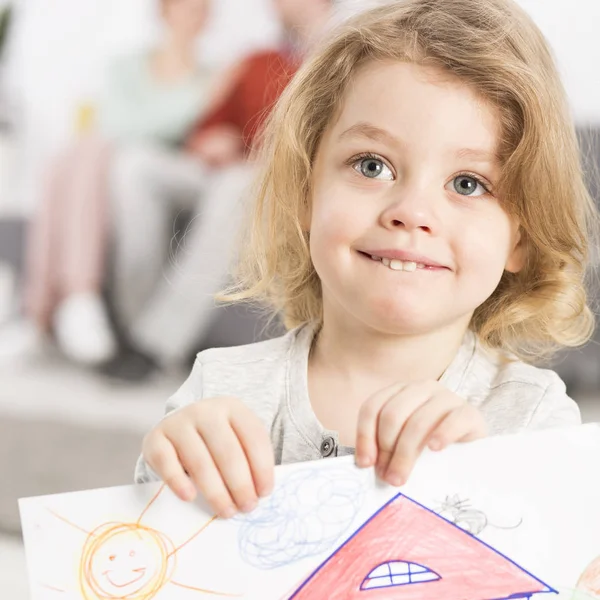 Sonriente niña sosteniendo el dibujo — Foto de Stock