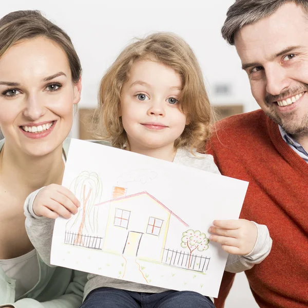 Padres jóvenes y niño sosteniendo imagen — Foto de Stock