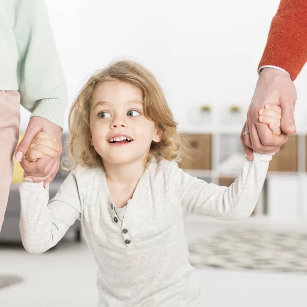 Menino alegre segurando as mãos dos pais — Fotografia de Stock