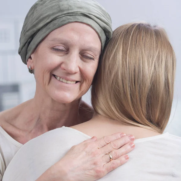 Улыбающаяся раковая женщина обнимает девушку — стоковое фото