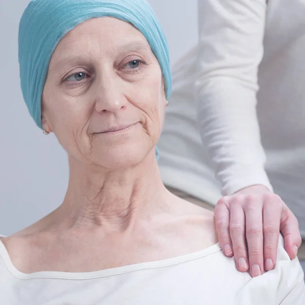 Person holding cancer woman\'s arm