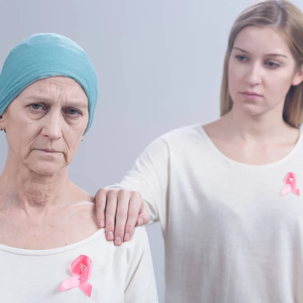 Tired cancer woman with pink ribbon