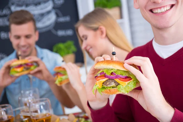 Hombre con hamburguesa sonriendo — Foto de Stock