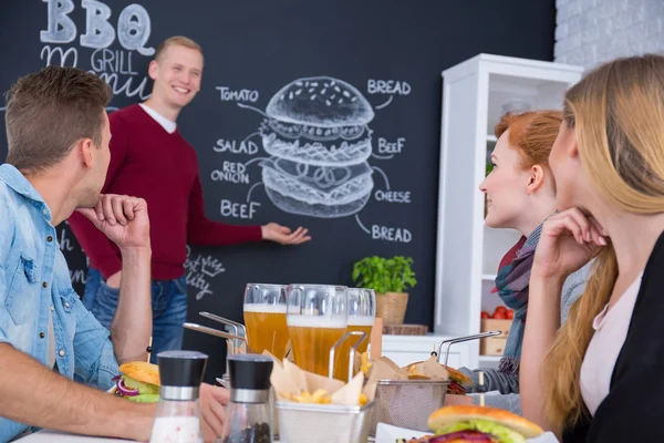 Muž, který stojí vedle menu na tabuli — Stock fotografie