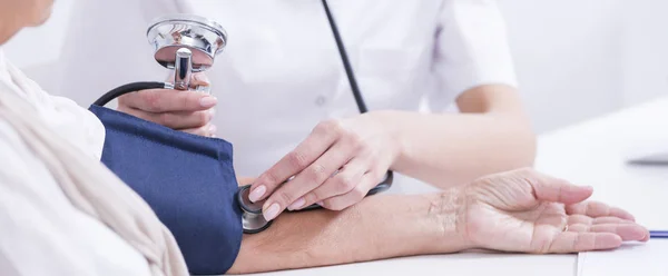 Médico midiendo la presión arterial del paciente — Foto de Stock