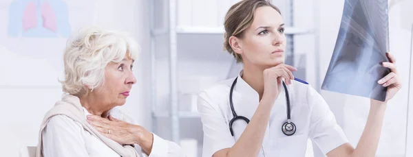 Dama y médico mirando rayos X —  Fotos de Stock