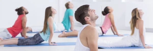 Avslappnad människor som utövar yoga — Stockfoto