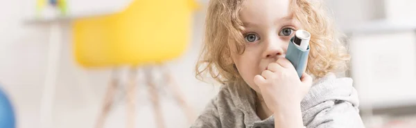 Blond liten pojke hålla inhalatorn — Stockfoto