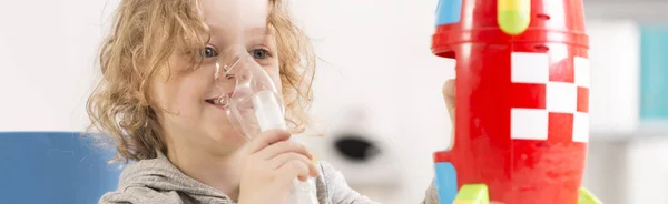 Anak menggunakan inhaler dan bermain dengan mainan — Stok Foto