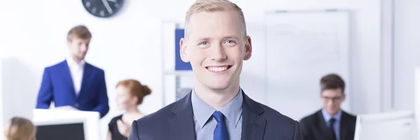 Smiling office worker with employees — Stock Photo, Image