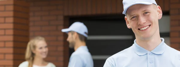 Hermoso mensajero con una camisa azul y una gorra — Foto de Stock