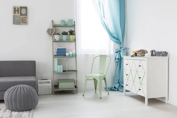 Acogedora habitación con sofá gris y cómoda blanca — Foto de Stock