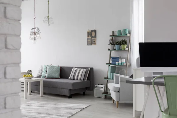 Вітальня з сірим диваном, журнальним столиком і білим кріслом — стокове фото