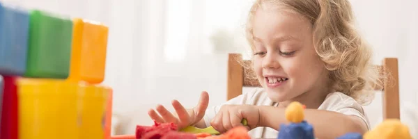 Girl playing with modeling clay — Stock Photo, Image