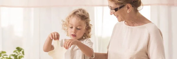 Chico cortar galletas con la abuela — Foto de Stock