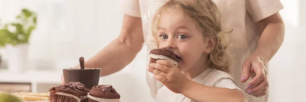 Jongen eten chocolade muffins — Stockfoto