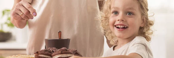 Ребенок перед кексами — стоковое фото