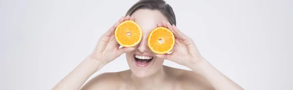 Mulher rindo segurando metades de laranja — Fotografia de Stock