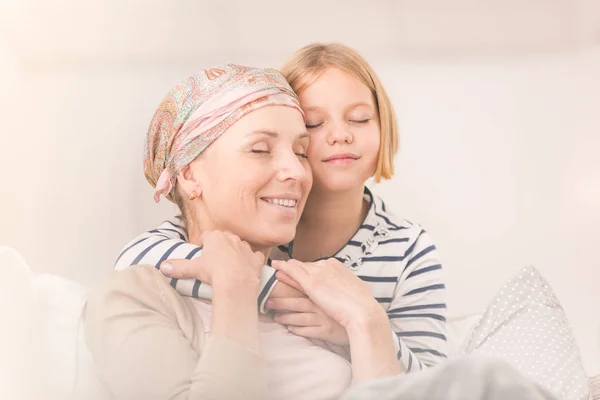 Child embracing ill mother — Stock Photo, Image
