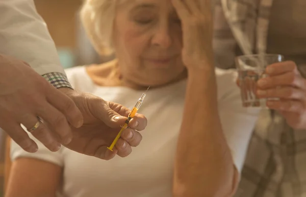 Mujer mayor, médico sosteniendo jeringa — Foto de Stock