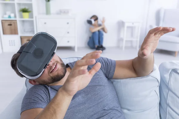 Hombre sentado en sofá con gafas VR — Foto de Stock