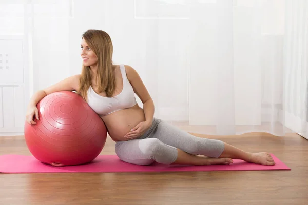 Έγκυος γυναίκα, κρατώντας την μπάλα γυμναστικής — Φωτογραφία Αρχείου