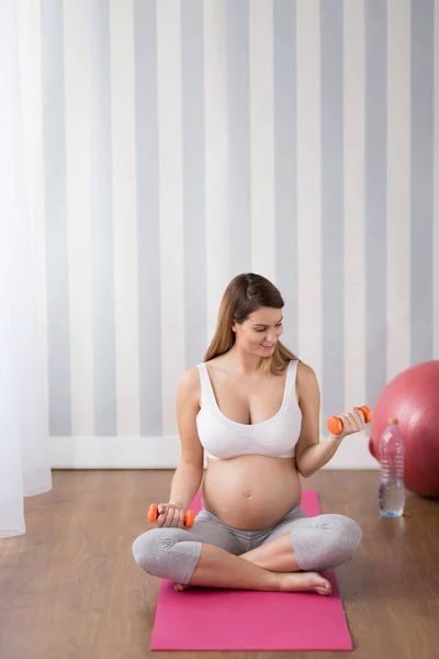 Pregnant woman exercising with dumbbells — Stock Photo, Image