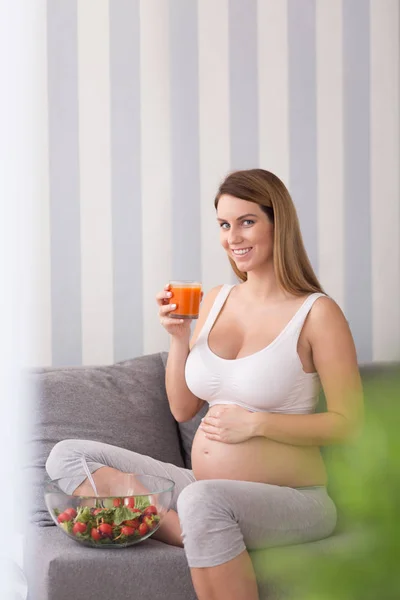 Mulher grávida bebendo suco de cenoura — Fotografia de Stock