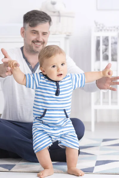Baby making first steps with father — Stock Photo, Image