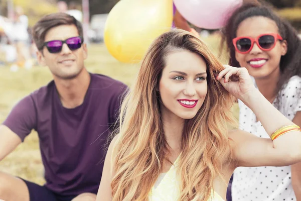 Mujer joven relajándose al aire libre con amigos — Foto de Stock