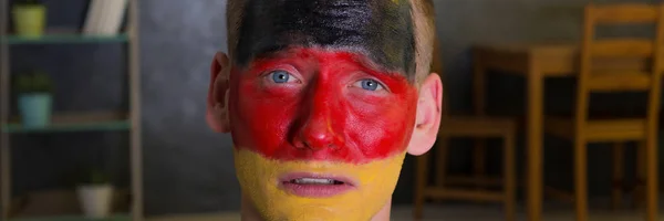 Лицо человека окрашено в немецкие цвета — стоковое фото