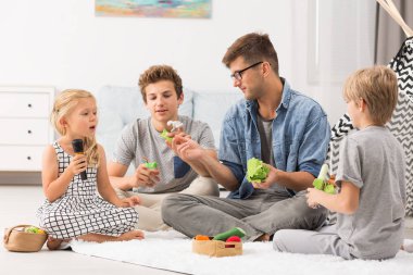 Baba ve çocuklar parmak kuklalar ile oynarken