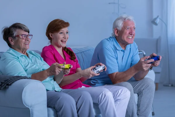 Elderly couple and caregiver playing — Stock Photo, Image