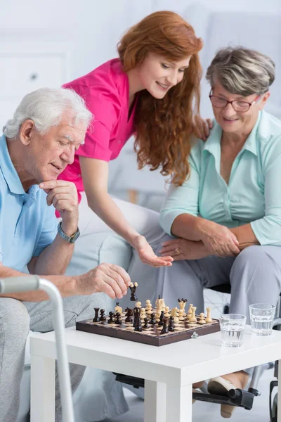 Casal jogando xadrez em casa de repouso — Fotografia de Stock