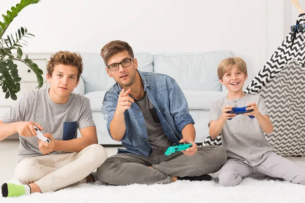 Tata, grając w gry wideo z synami — Zdjęcie stockowe