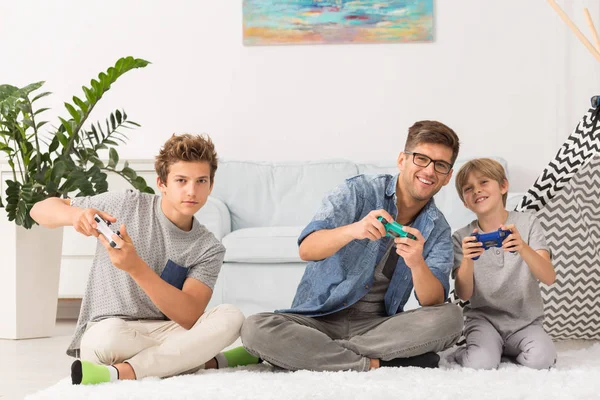 Ojciec i synowie, grając w gry wideo — Zdjęcie stockowe