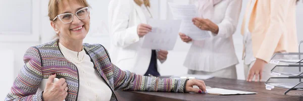 Éxito mujer de mediana edad por escritorio — Foto de Stock