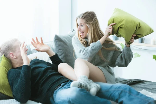 Paar liefert sich Kissenschlacht — Stockfoto