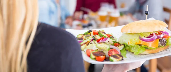 Serveerster serveren een hamburger — Stockfoto