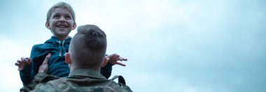 Panoramik bir askerin oğlu onun kollarında