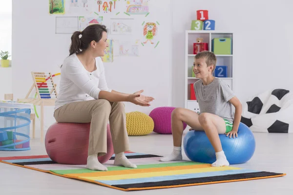 Physiotherapist sitting on gym ball — Stock Photo, Image