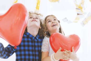 Child couple with balloon hearts clipart
