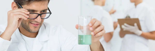 Wissenschaftler hält Becher mit Flüssigkeit — Stockfoto