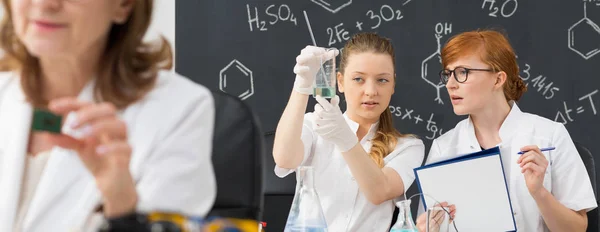 Estudiantes analizando reactivos en tubo — Foto de Stock